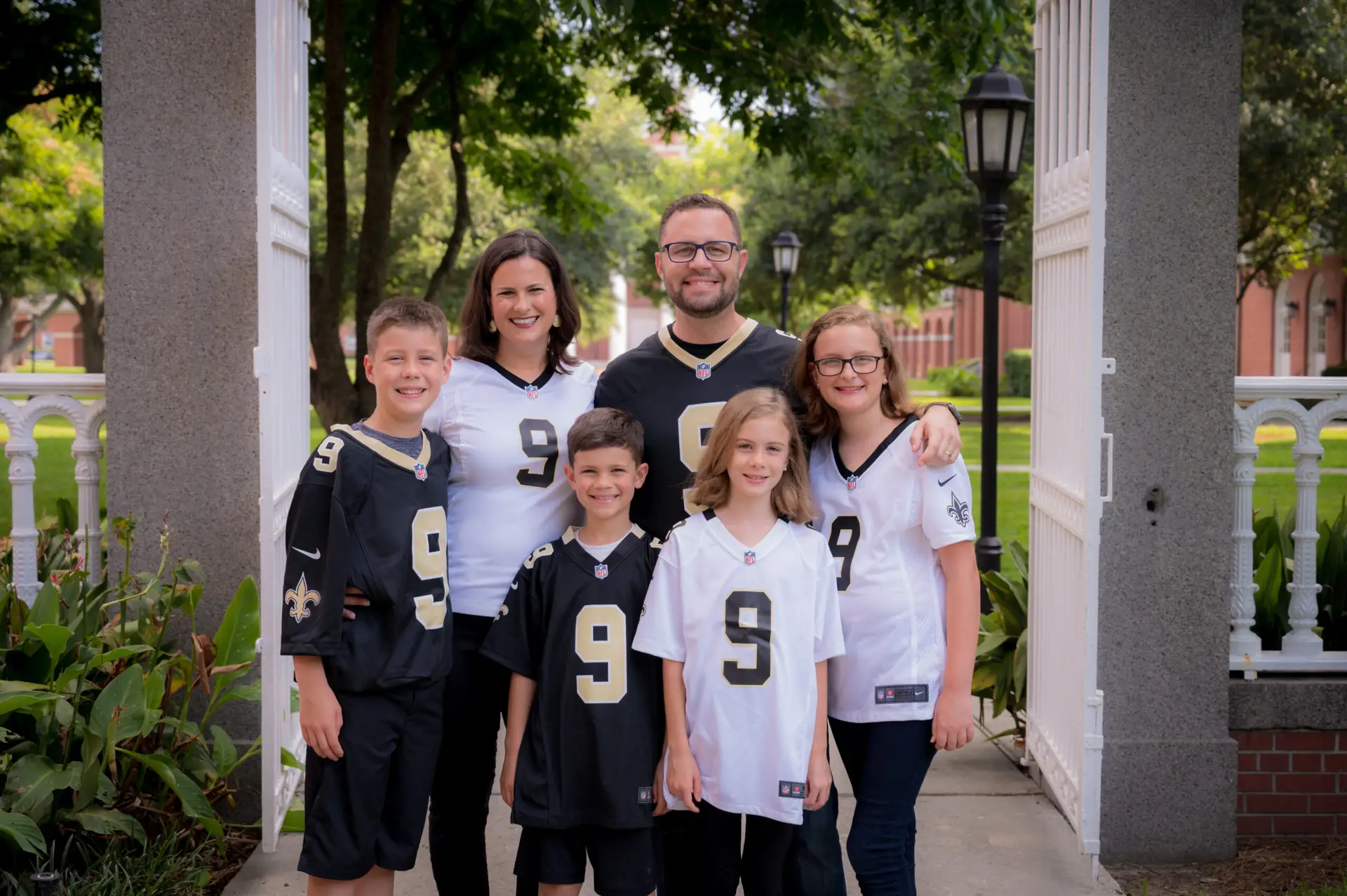 Jamie Dew, Tara Dew, and their 4 children wear Saints jerseys sporting the number 9